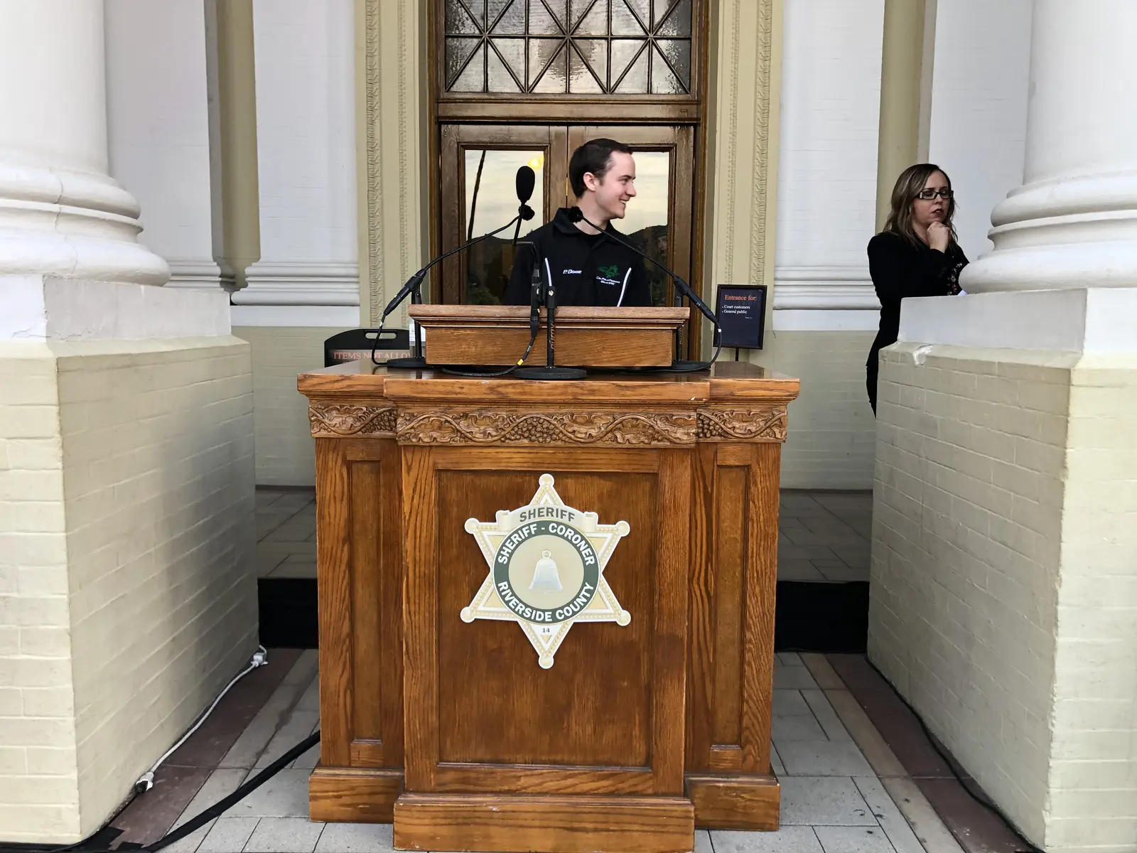 Presenters at a podium in a formal hall